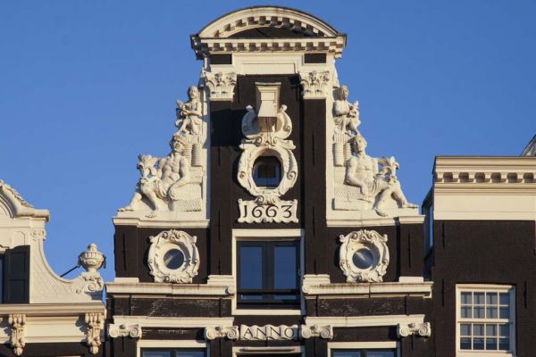 OZ Voorburgwal 187. Halsgevel met negrode figuren in de klauwstukken.