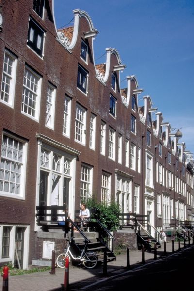 Het Grill's Hofje ligt achter een identieke rij klokgevels in de Eerste Weteringdwarsstraat.