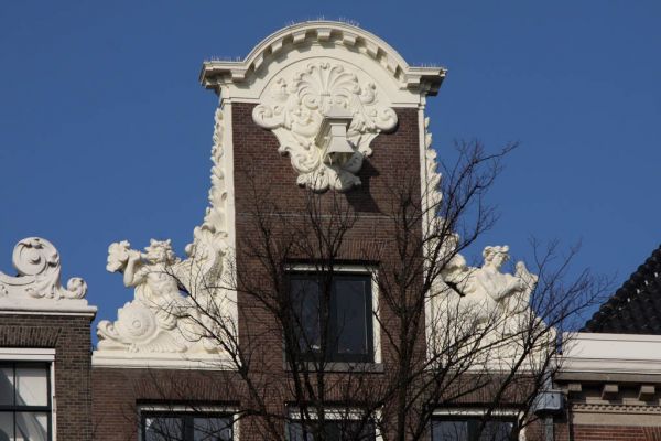 Halsgeveltop met klauwstukken met dolfijnen en mensenfiguren: Arion met lier en Triton met hoorn (&copy; Walther Schoonenberg)