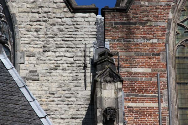 Oude Kerk. Natuurstenen gevels (van witte Gobertanger steen) en bakstenen gevels (met speklagen van natuursteen).