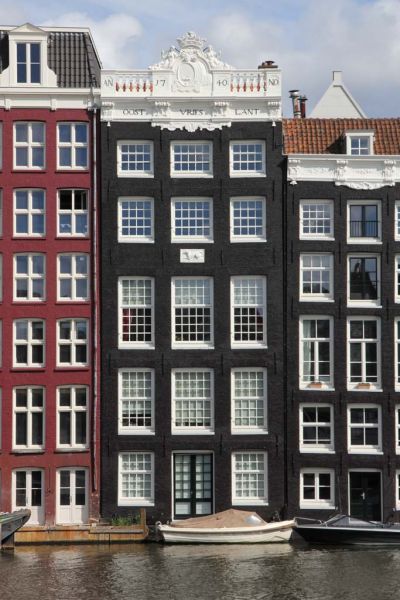 Achtergevel van Warmoesstraat 16 in het water van het Damrak (&copy; Walther Schoonenberg)