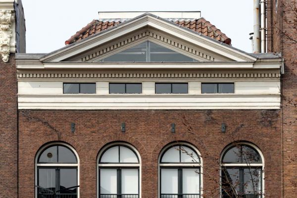Groot driehoekig fronton van hout op de kroonlijst