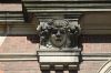 Detail van het toegangspoortje: een stenen gaper (&copy; Walther Schoonenberg)