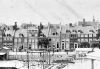 Noordzijde van het Frederiksplein met aan beide zijde van nr. 10 dwarshuizen. Detail van een foto uit 1865. Noordzijde van het Frederiksplein met aan beide zijde van nr. 10 dwarshuizen. Detail van een foto uit 1865.