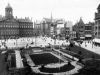 Het plantsoen op de Dam in 1926. Op de achtergrond het Koninklijk Paleis en de Nieuwe Kerk.