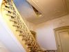 Interieur van gang en trappenhuis met stucwerk en trapbalusters