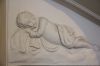 Stucreli�f in de gang, boven de deur naar souterrain achterhuis: Een slapende putto (&copy; Walther Schoonenberg)