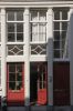 Detail van de onderpui met ingang voor de bovenwoningen in het midden (&copy; Walther Schoonenberg)