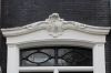 Detail van de deuromlijsting met Rococo kuif (Noorderstraat 74) (© Walther Schoonenberg)